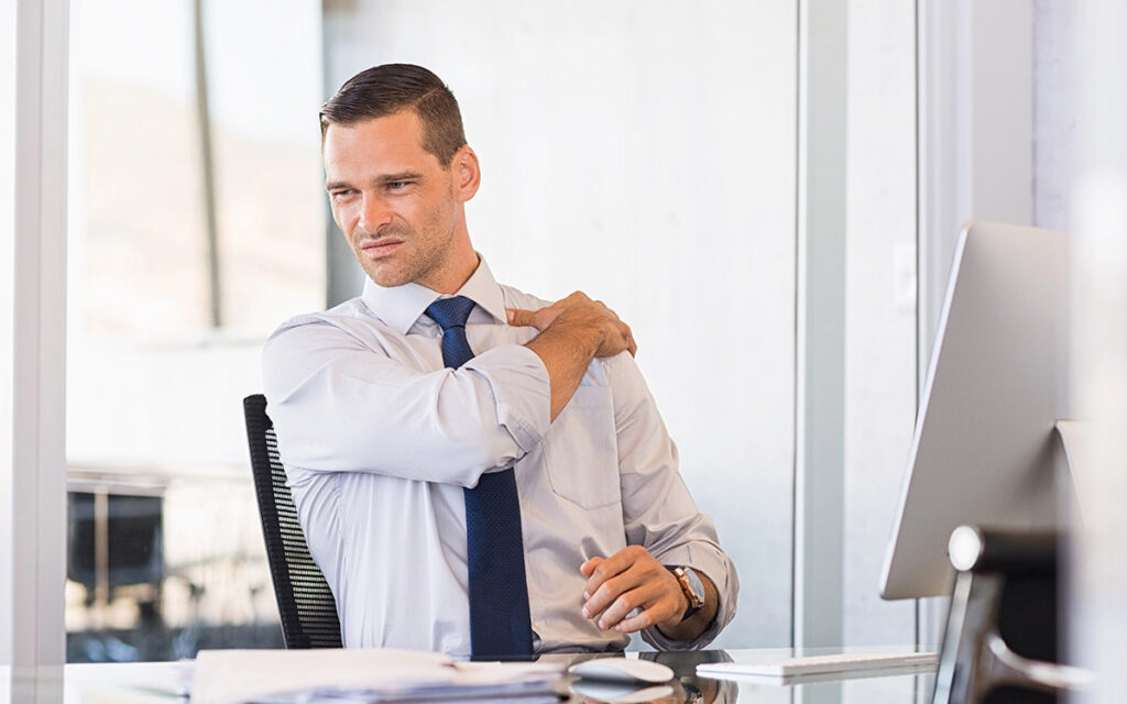 man working at the office with shoulder pain